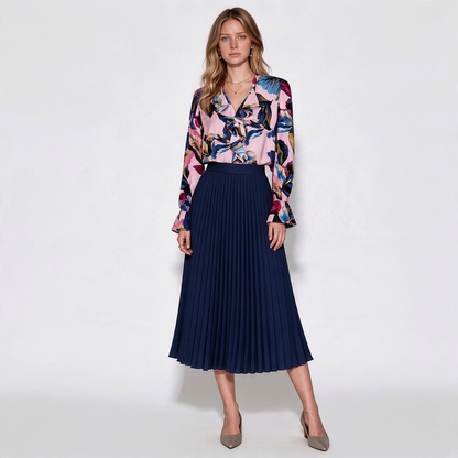 Model wearing Lynn's Closet Boutique Elie Tahari silk-blend floral blouse with ruffled details and navy pleated skirt