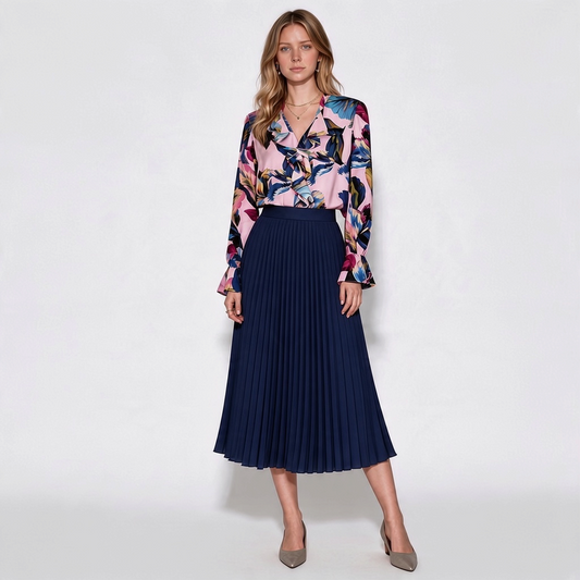 Model wearing Lynn's Closet Boutique Elie Tahari silk-blend floral blouse with ruffled details and navy pleated skirt