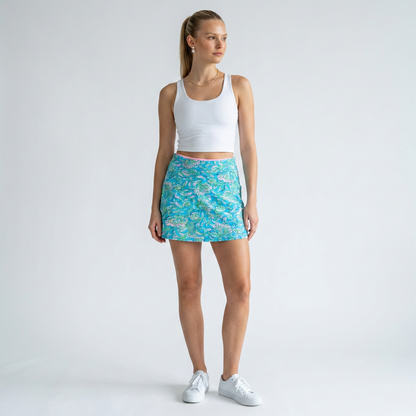 Model wearing Lynn's Closet Boutique Lilly Pulitzer Luxletic skort with turquoise floral print and white tank top