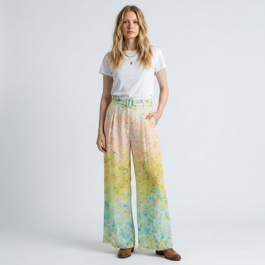Model wearing Lynn's Closet Boutique wide-leg pleated pants with watercolor floral print in peach, yellow, and blue.