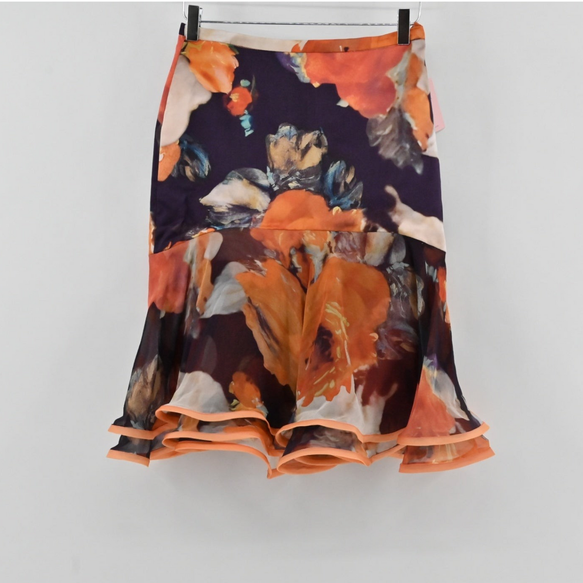 Lynn's Closet Boutique Manzoni Couture floral ruffle skirt with orange and cream painterly print on a dark base.