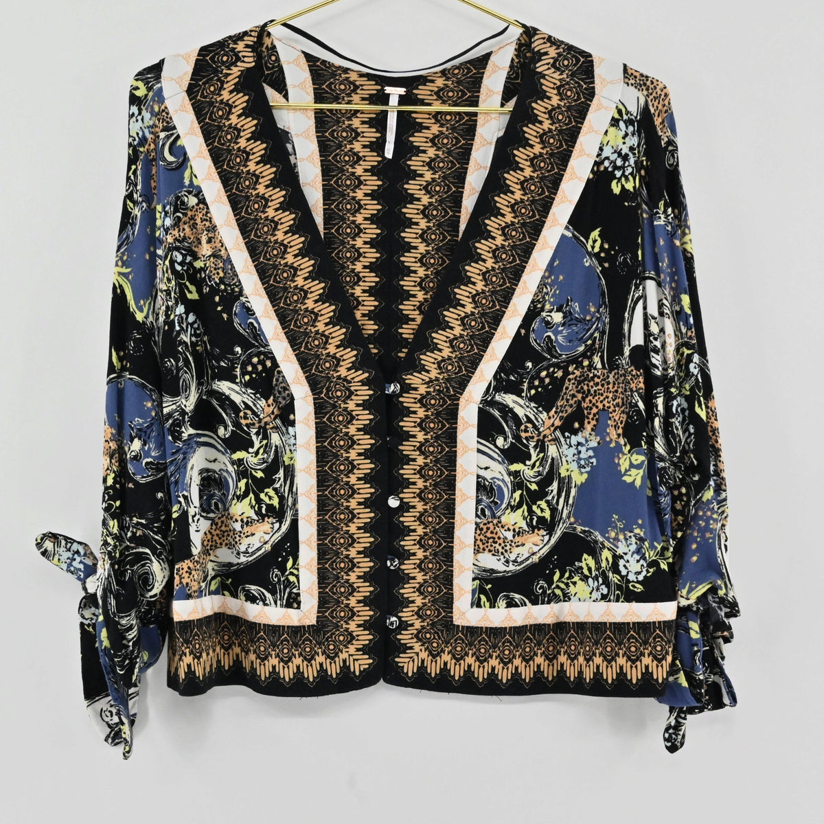 Lynn's Closet Boutique Free People bohemian V-neck top with multi-colored floral print and tie-sleeve details.