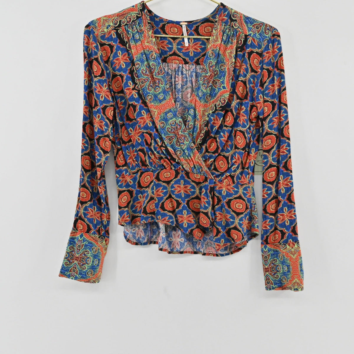 Lynn's Closet Boutique Free People Falling For You long-sleeve wrap top with a vibrant floral and paisley print.