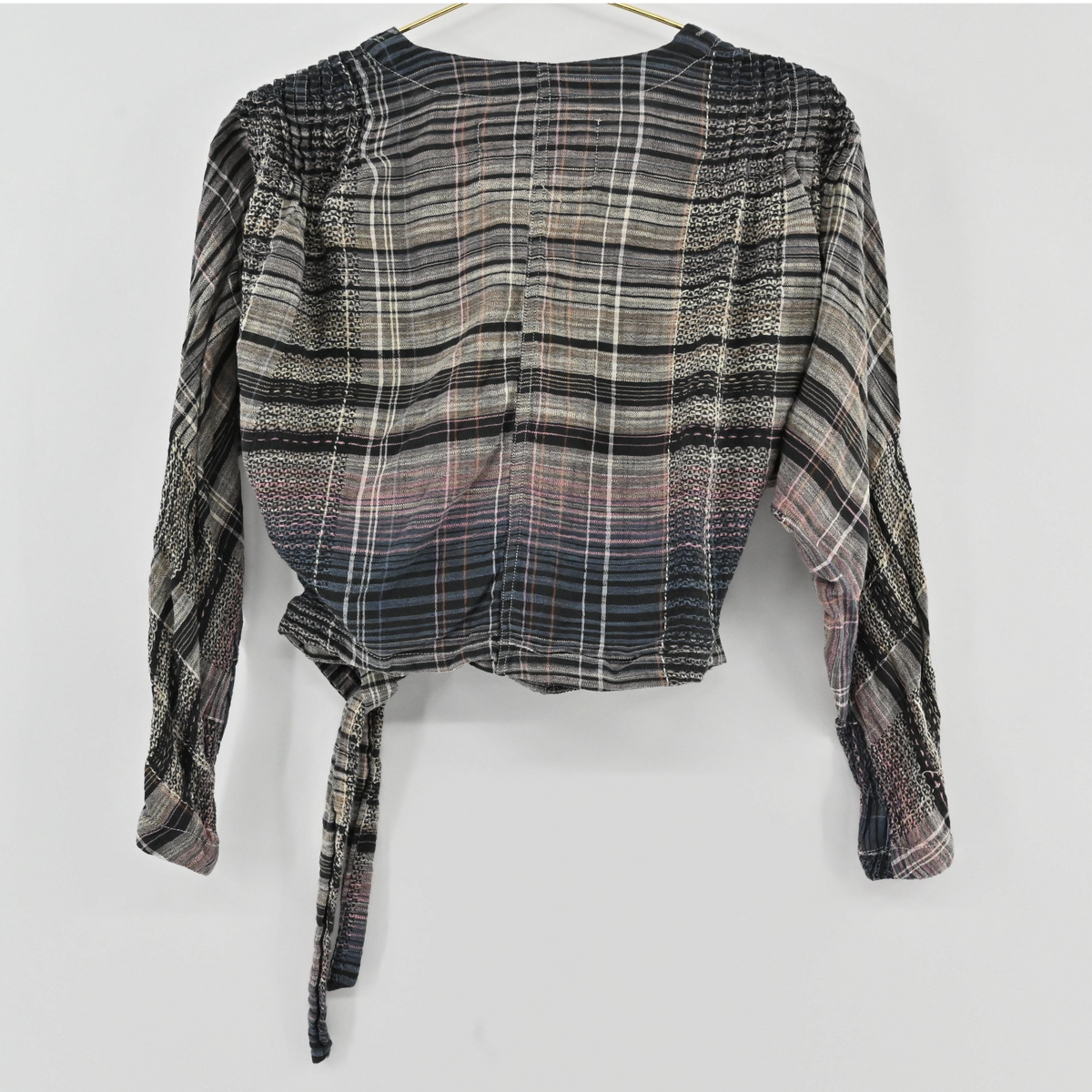 Lynn's Closet Boutique Free People plaid wrap top with long sleeves, shirred shoulders, and a side tie in a gradient.