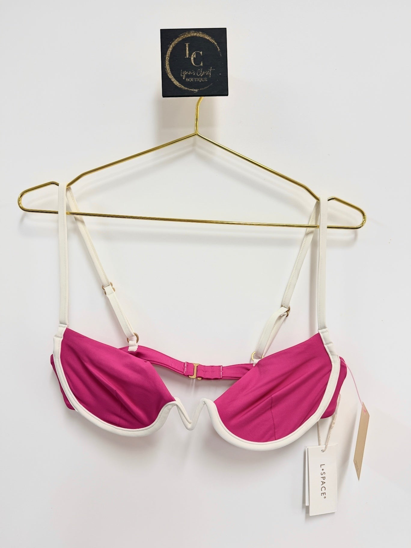 Lynn's Closet Boutique L Space fuchsia bikini top with white piping and underwire support on a gold hanger.
