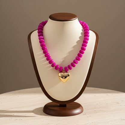 Lynn's Closet Boutique chunky fuchsia acrylic bead necklace with a polished gold-tone heart pendant on a display bust.