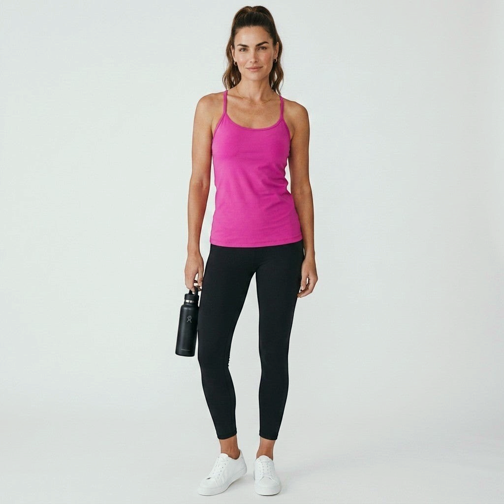 Model wearing a fuchsia Lululemon Power Y tank top from Lynn's Closet Boutique with black leggings and white sneakers.