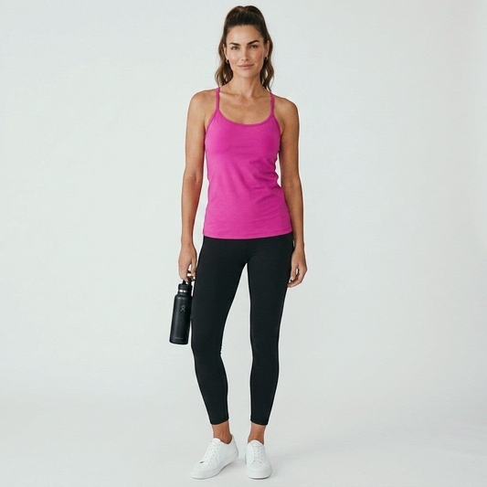 Model wearing a fuchsia Lululemon Power Y tank top from Lynn's Closet Boutique with black leggings and white sneakers.