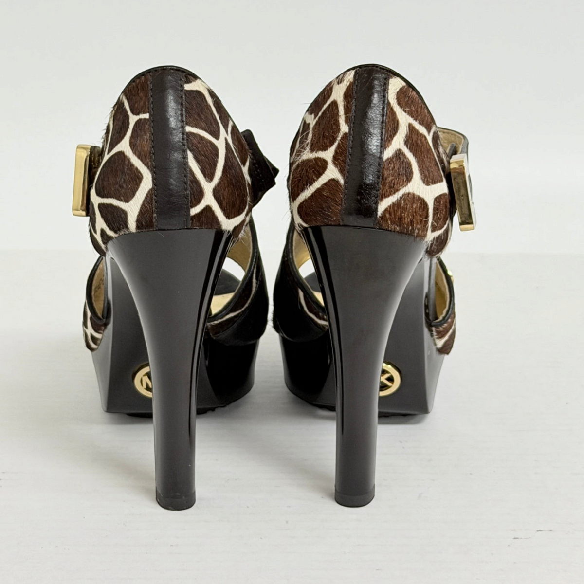 Lynn's Closet Boutique Michael Kors giraffe-print calf hair platform heels with gold buckles and dark leather heels.