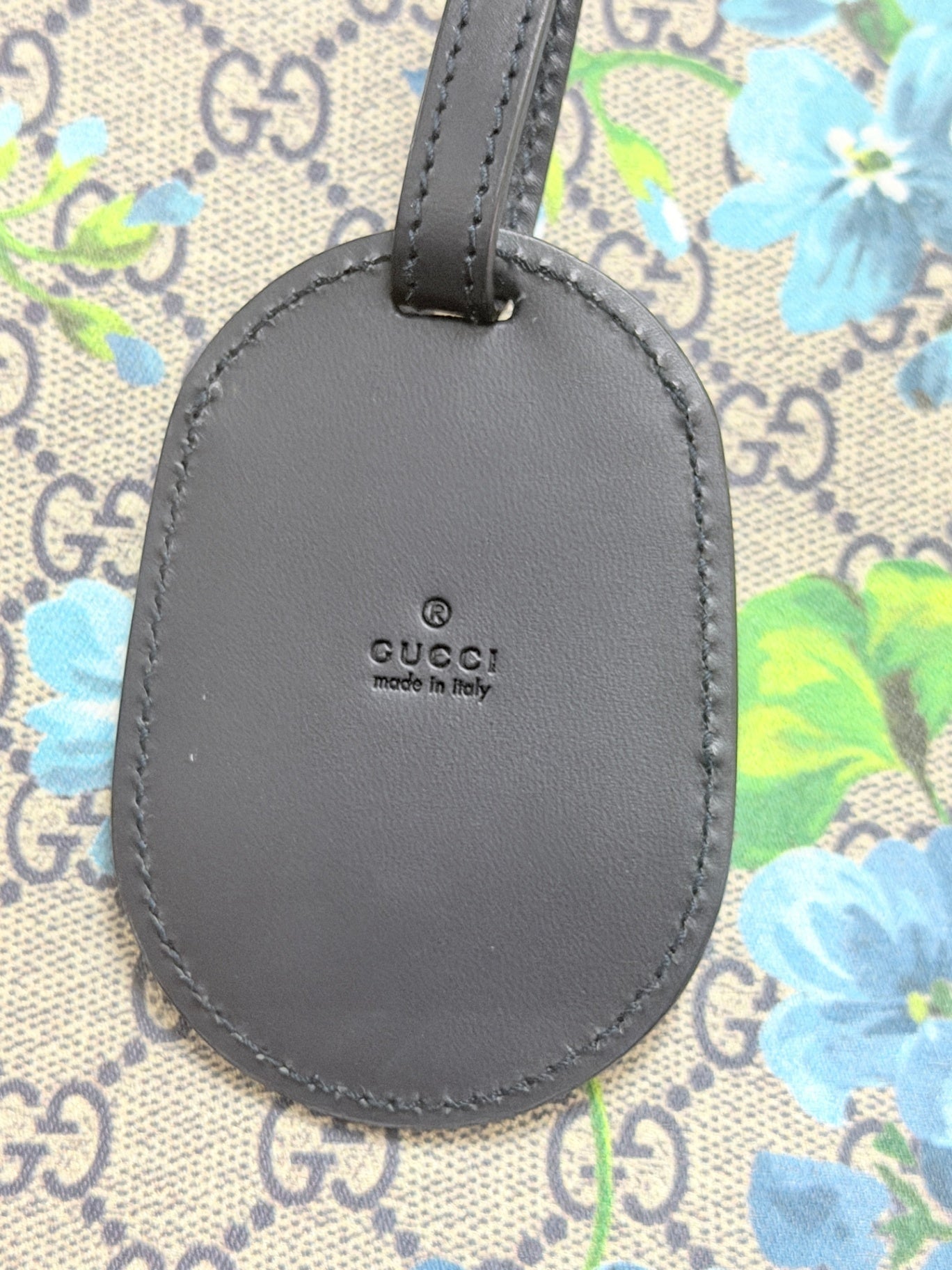 Lynn's Closet Boutique Gucci GG Supreme floral tote black leather luggage tag with embossed logo