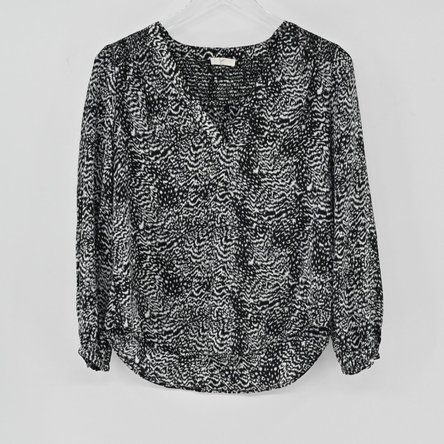Lynn's Closet Boutique Joie black and white silk animal print blouse with V-neck and long sleeves on a hanger