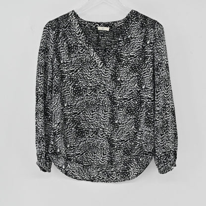 Lynn's Closet Boutique Joie black and white silk animal print blouse with V-neck and long sleeves on a hanger