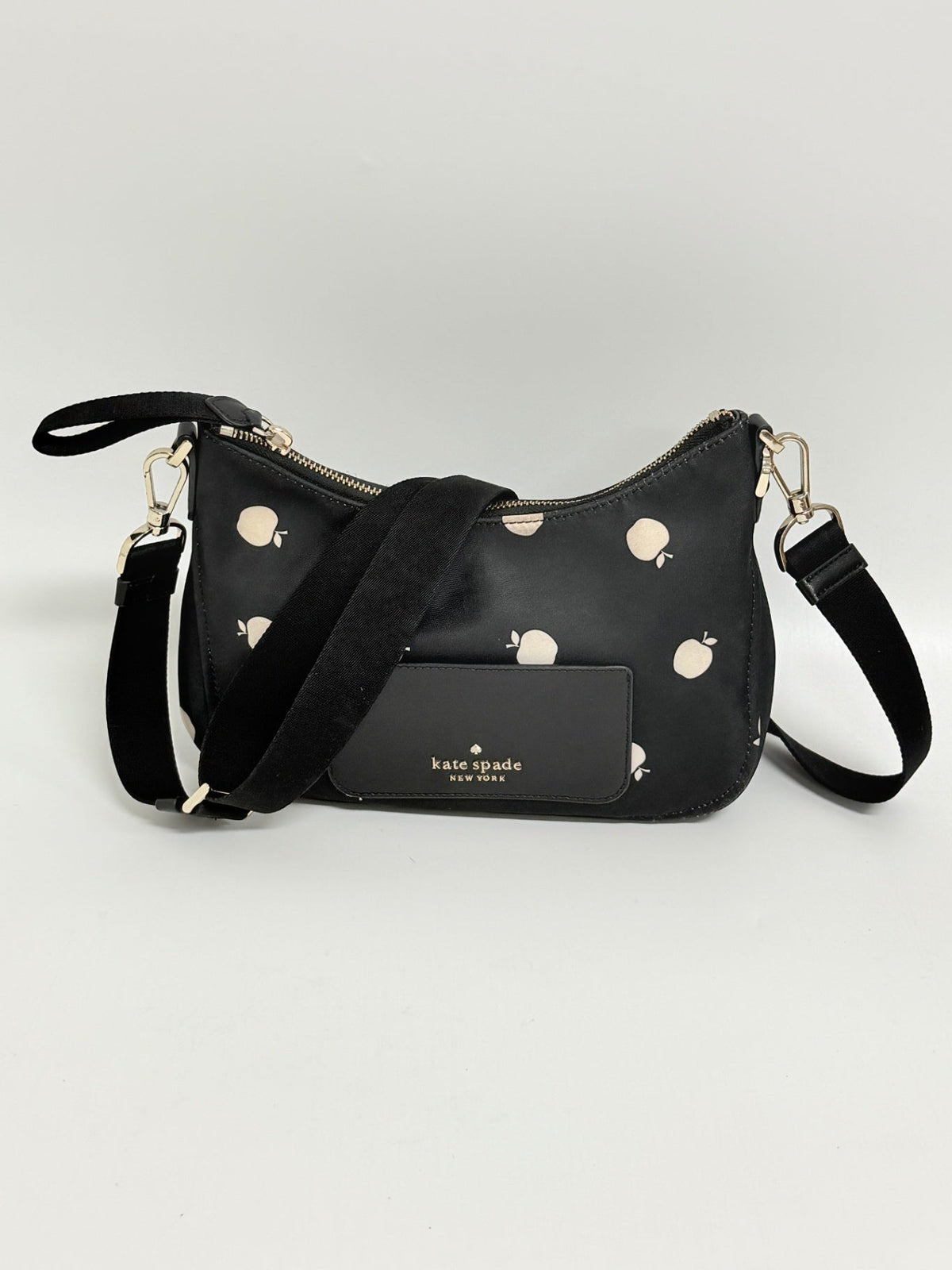 Lynn's Closet Boutique Kate Spade Chelsea nylon crossbody bag in black with a white apple print and adjustable strap.