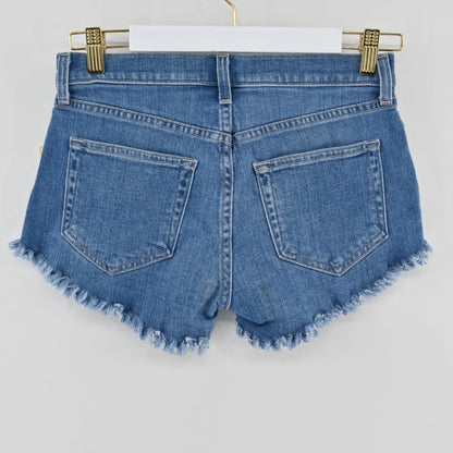 Lynn's Closet Boutique L'Agence Zoe medium-blue denim cut-off shorts with raw-edge hem and five-pocket styling.