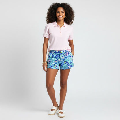 Model wearing Lynn's Closet Boutique Lilly Pulitzer Callahan shorts in blue Turtle Villa print with a pink polo shirt