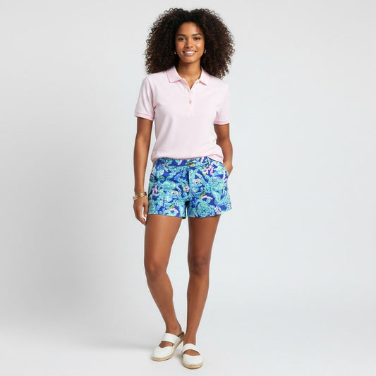 Model wearing Lynn's Closet Boutique Lilly Pulitzer Callahan shorts in blue Turtle Villa print with a pink polo shirt