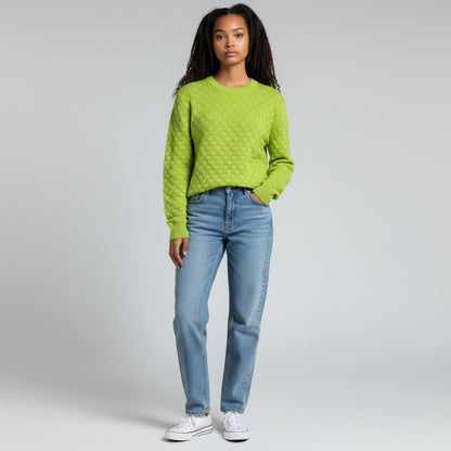 Model wearing a lime green Louis Vuitton Damier sweater from Lynn's Closet Boutique with blue jeans and sneakers.