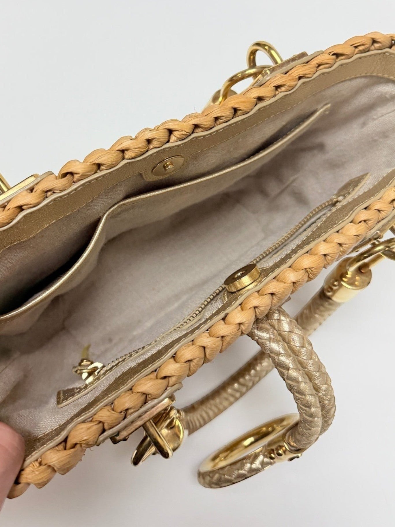 Interior view of a Lynn's Closet Boutique Michael Kors raffia tote with gold leather trim and braided handles.