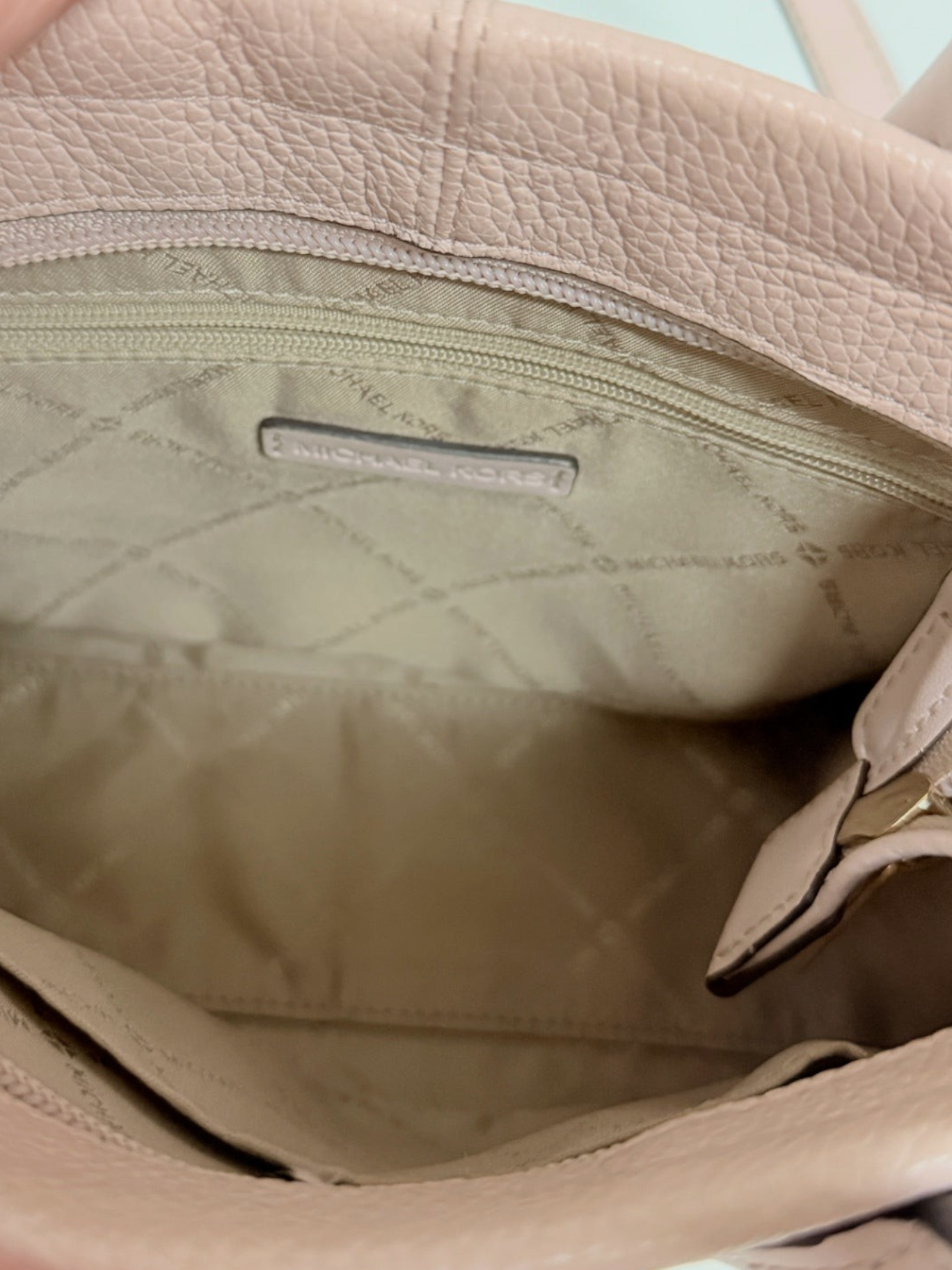 Interior of Lynn's Closet Boutique Michael Kors blush pebbled leather tote with logo lining and zippered pocket