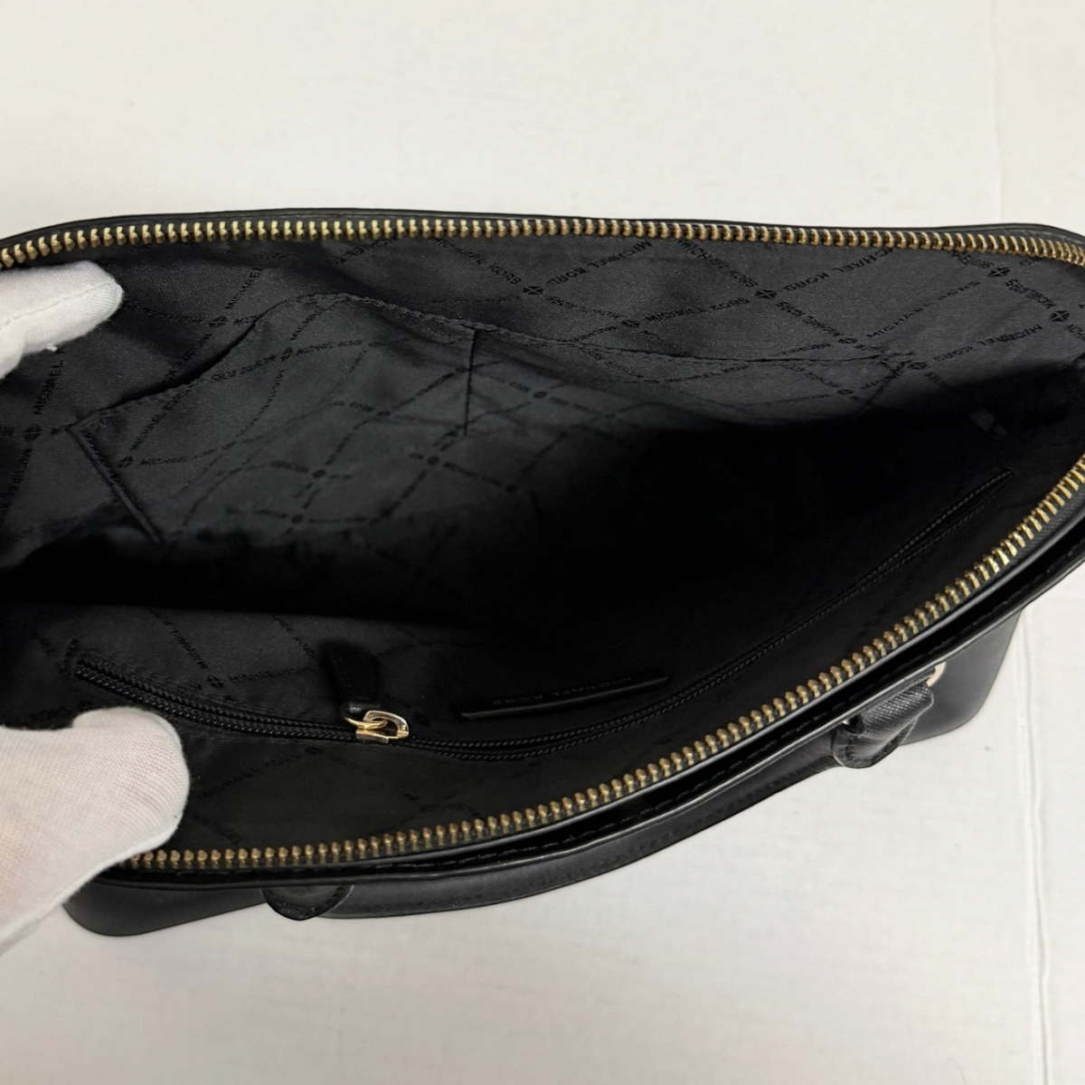 Interior view of Lynn's Closet Boutique Michael Kors black tote featuring signature fabric lining and zip pocket