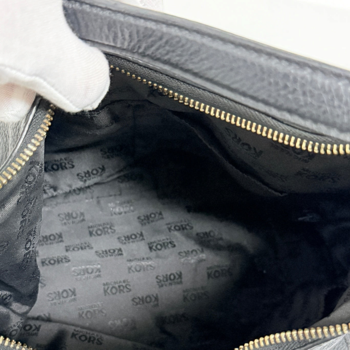 Interior of a Lynn's Closet Boutique Michael Kors black leather tote with signature logo fabric lining and gold zipper