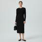 Model wearing a black Misook midi dress with a ribbed collar from Lynn's Closet Boutique, styled with black flats.