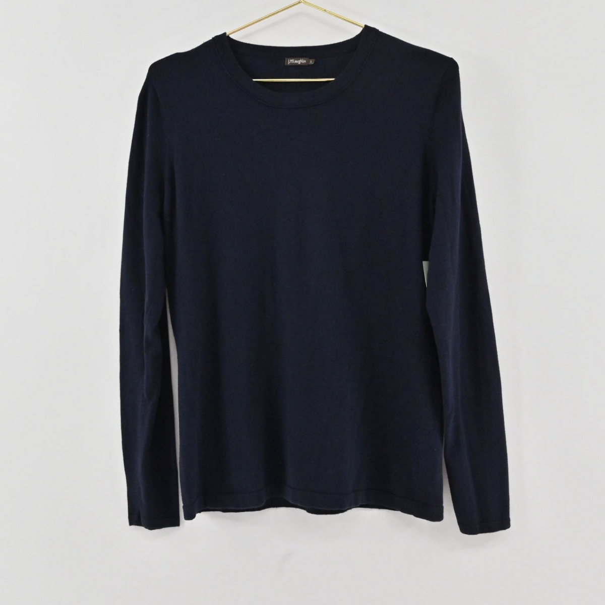 Lynn's Closet Boutique navy blue crew neck sweater in a lightweight knit, size L, hanging on a gold hanger.