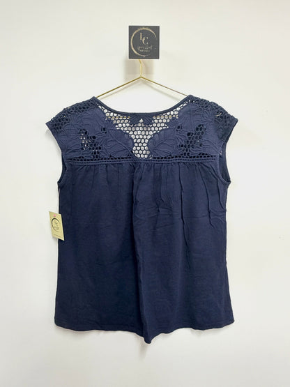 Lynn's Closet Boutique navy sleeveless top with intricate crochet yoke detailing on a gold hanger