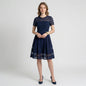 Model wearing a Lynn's Closet Boutique navy Elliatt dress with semi-sheer horizontal striped panels and pleated skirt.