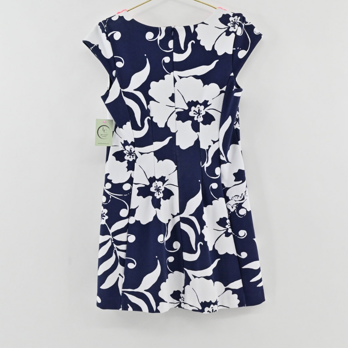 Lynn's Closet Boutique navy and white floral print mini dress with cap sleeves hanging on a hanger