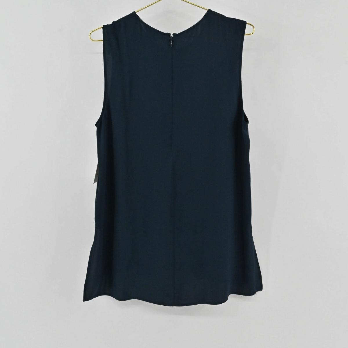 Lynn's Closet Boutique navy blue sleeveless silk top with a back zipper closure hanging on a gold hanger