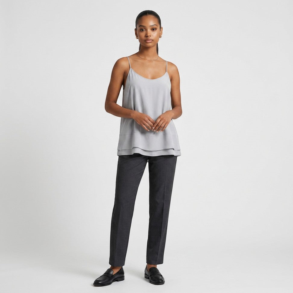 Model wearing Lynn's Closet Boutique Nouvelle 95Silk gray camisole with layered hem, spaghetti straps, and dark trousers