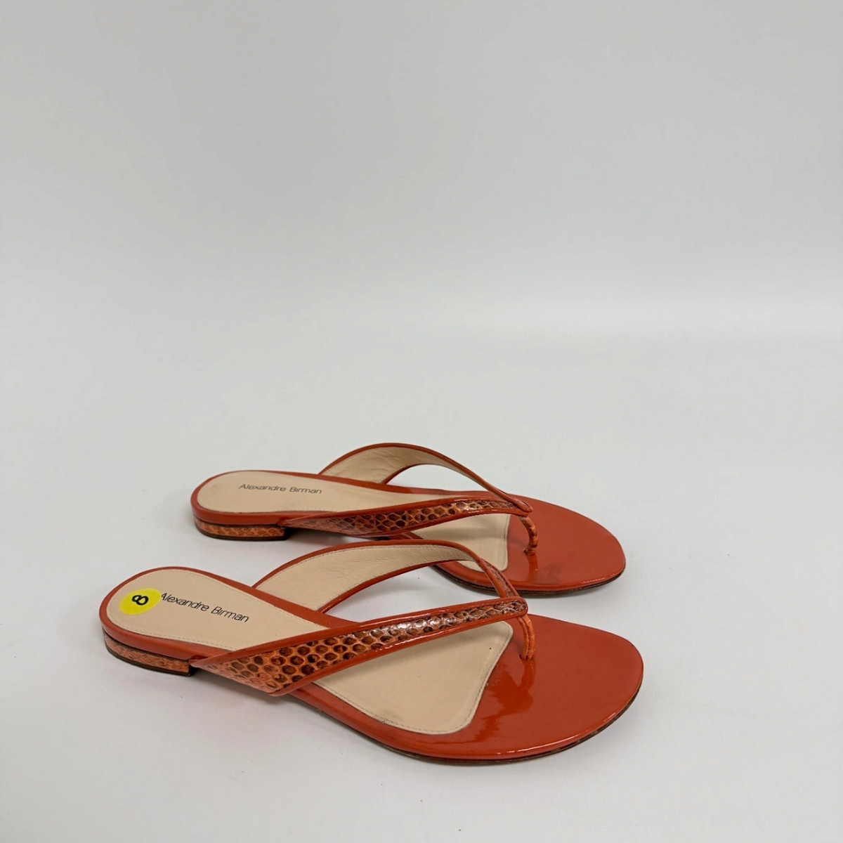 Lynn's Closet Boutique Alexandre Birman orange flat thong sandals with snakeskin-embossed straps and glossy finish.