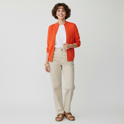 Lynn's Closet Boutique model wearing a vibrant orange St. John Sport zip-up sweater with textured knit chest detail.