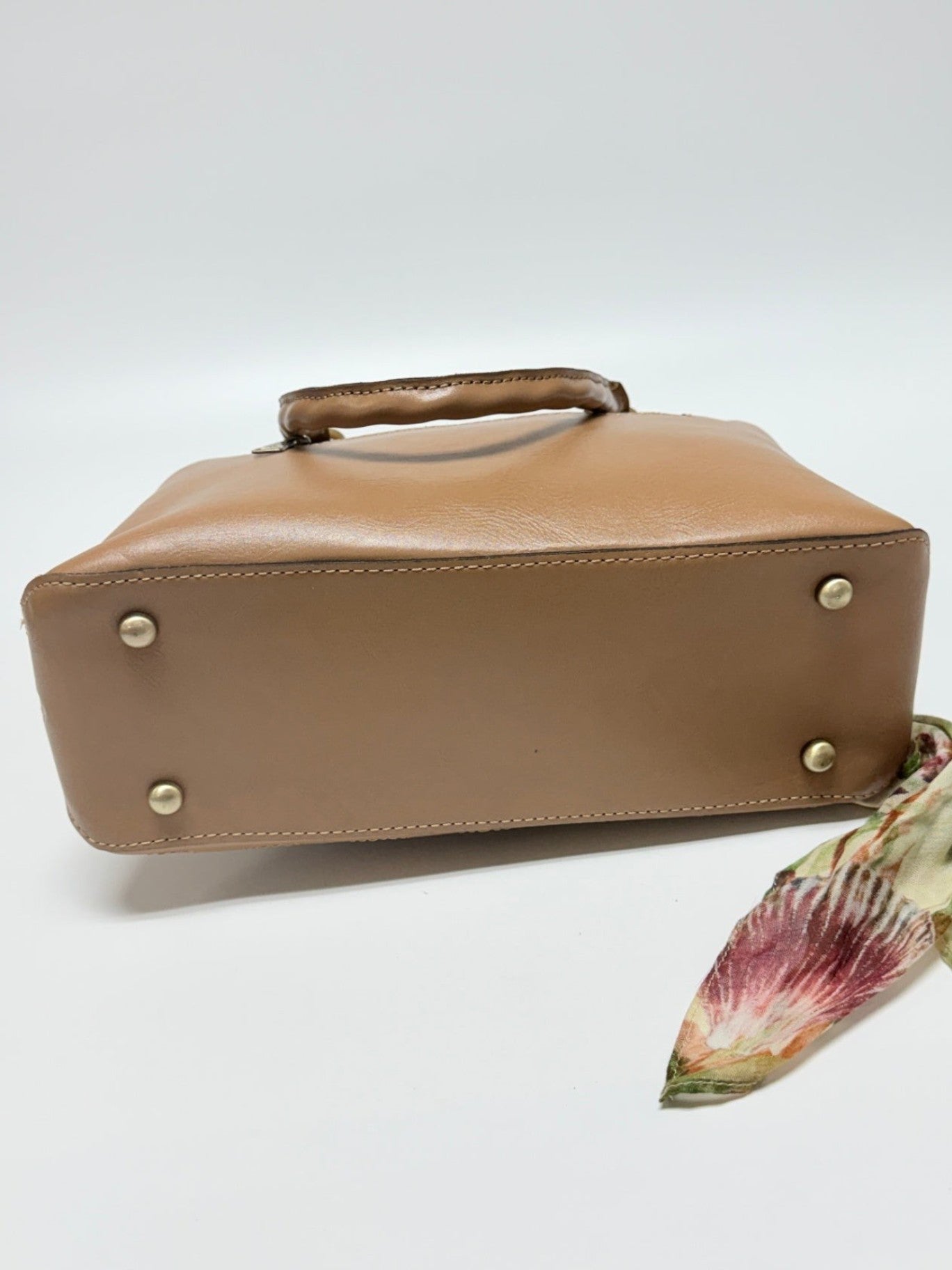 Lynn's Closet Boutique Patricia Nash Angela satchel bottom view showing protective metal feet and camel leather base.