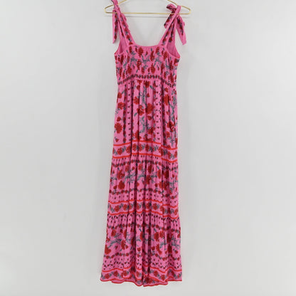 Lynn's Closet Boutique Beach Riot Charlotte pink floral maxi dress with tie straps and a tiered skirt on a hanger.