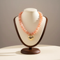 Lynn's Closet Boutique pink acrylic chunky bead necklace with a polished gold-tone heart pendant on a display bust.