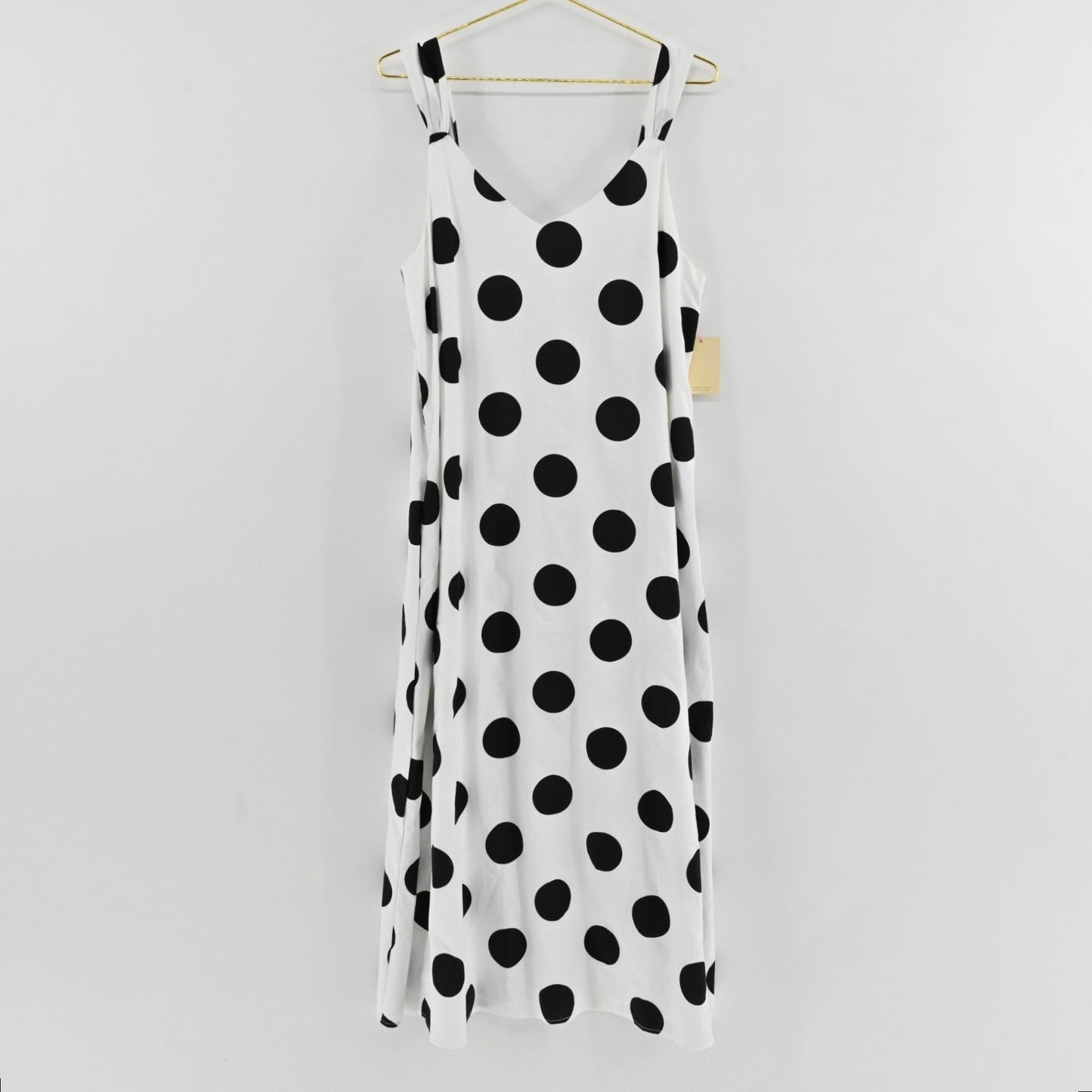Lynn's Closet Boutique Pomander Place white midi dress with black polka dots, V-neck, and sleeveless relaxed fit.