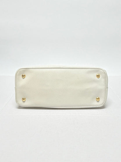 Lynn's Closet Boutique white Prada Galleria Saffiano leather handbag base with four protective gold-tone metal feet.