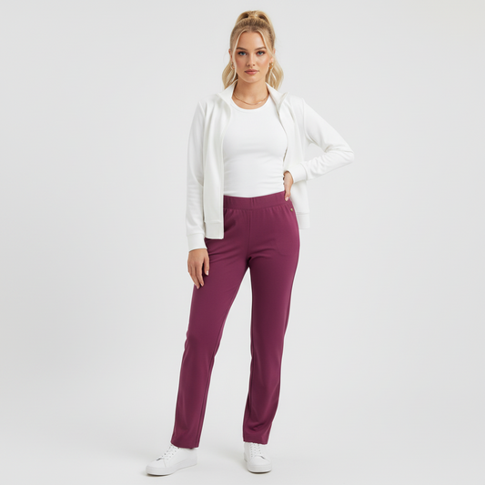 Model wearing Lynn's Closet Boutique purple Lilly Pulitzer leggings with a white zip-up jacket and sneakers