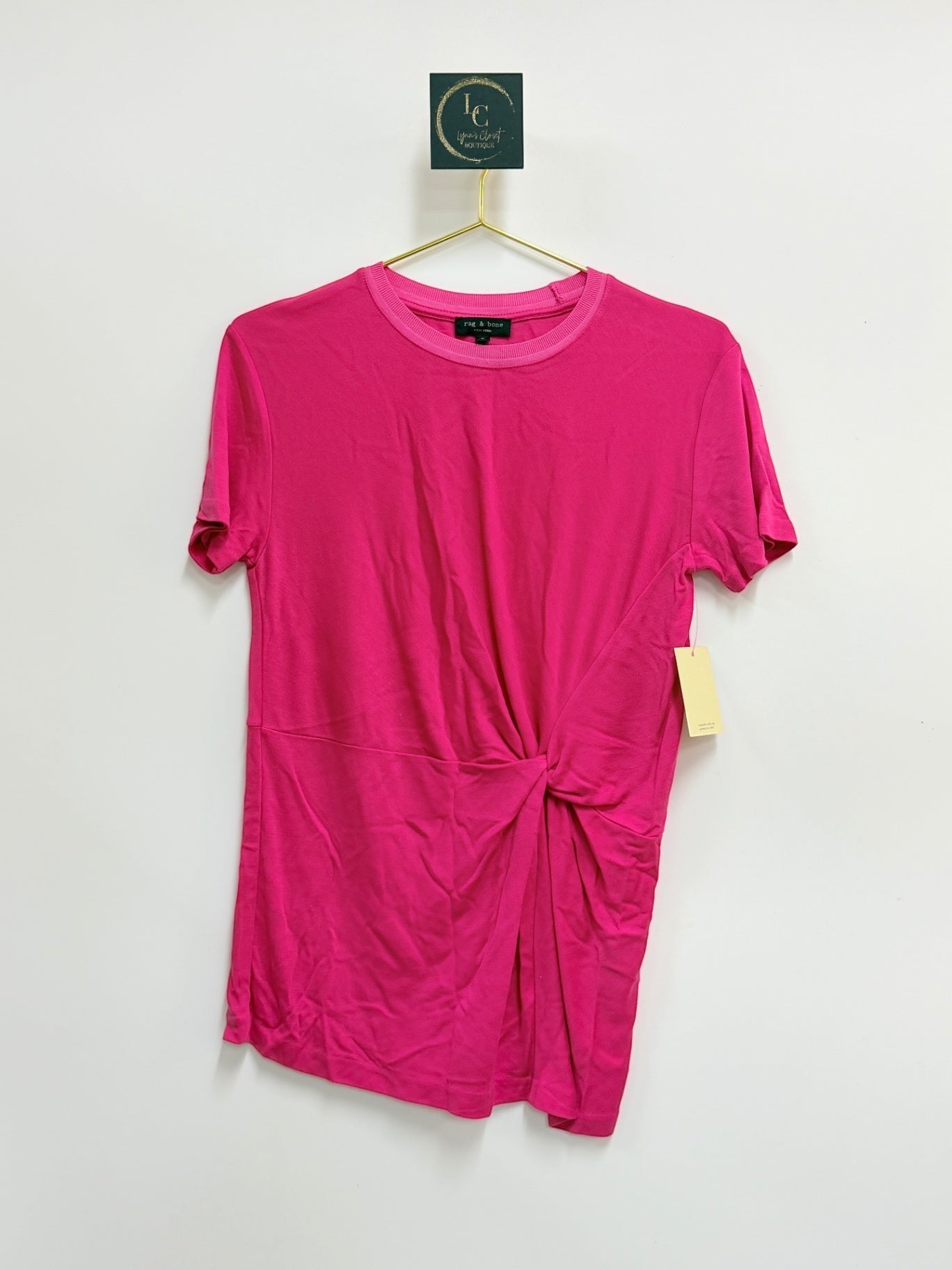 Lynn's Closet Boutique Rag & Bone fuchsia short-sleeve top with side-knot detail and crew neck on a hanger.