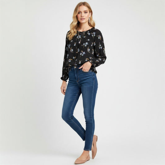 Model wearing Lynn's Closet Boutique Rebecca Taylor black floral silk top with smocked cuffs and dark wash skinny jeans