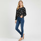Model wearing Lynn's Closet Boutique Rebecca Taylor black floral silk top with smocked cuffs and dark wash skinny jeans