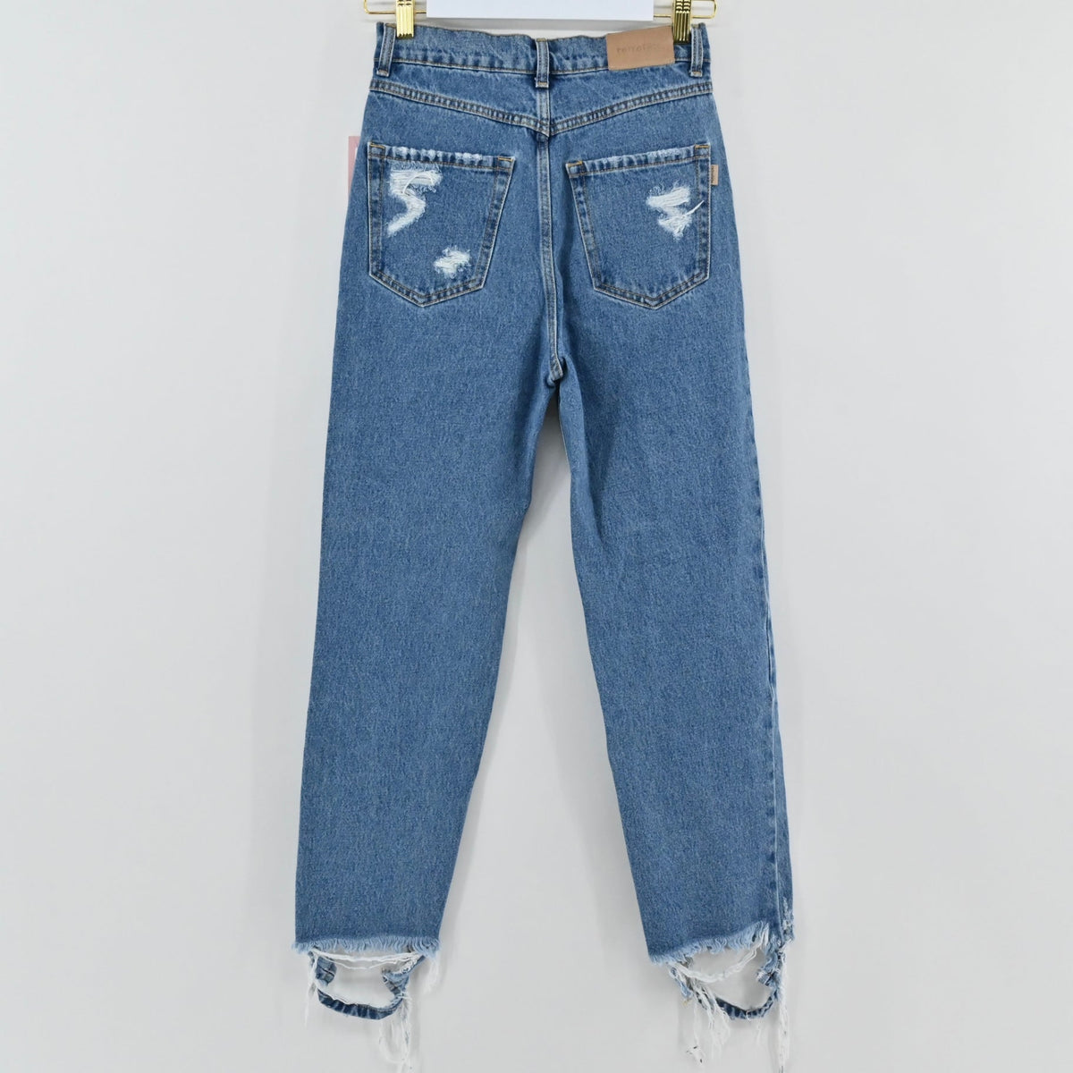 Lynn's Closet Boutique Retrofête medium-blue high-rise distressed jeans with frayed hem, back view.