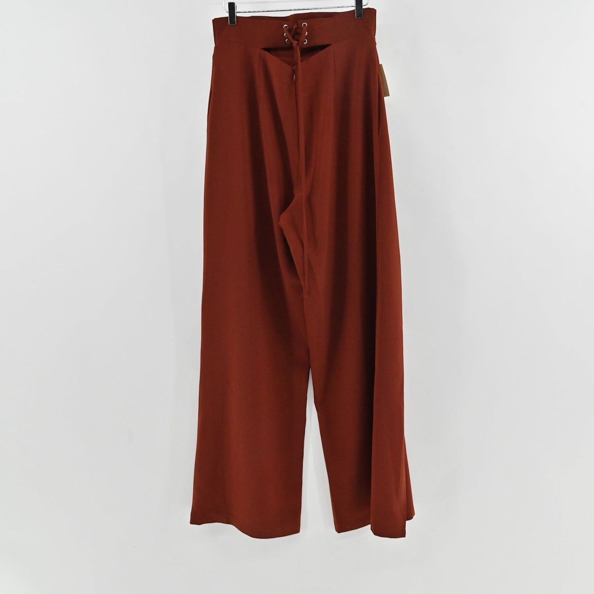 Lynn's Closet Boutique Andrea Iyamah rust-brown wide-leg trousers with lace-up back detail hanging on a hanger