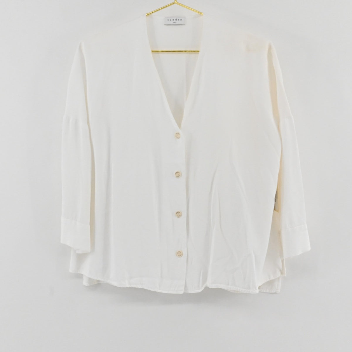 Lynn's Closet Boutique Sandro white V-neck button-down top with long sleeves and structured cuffs