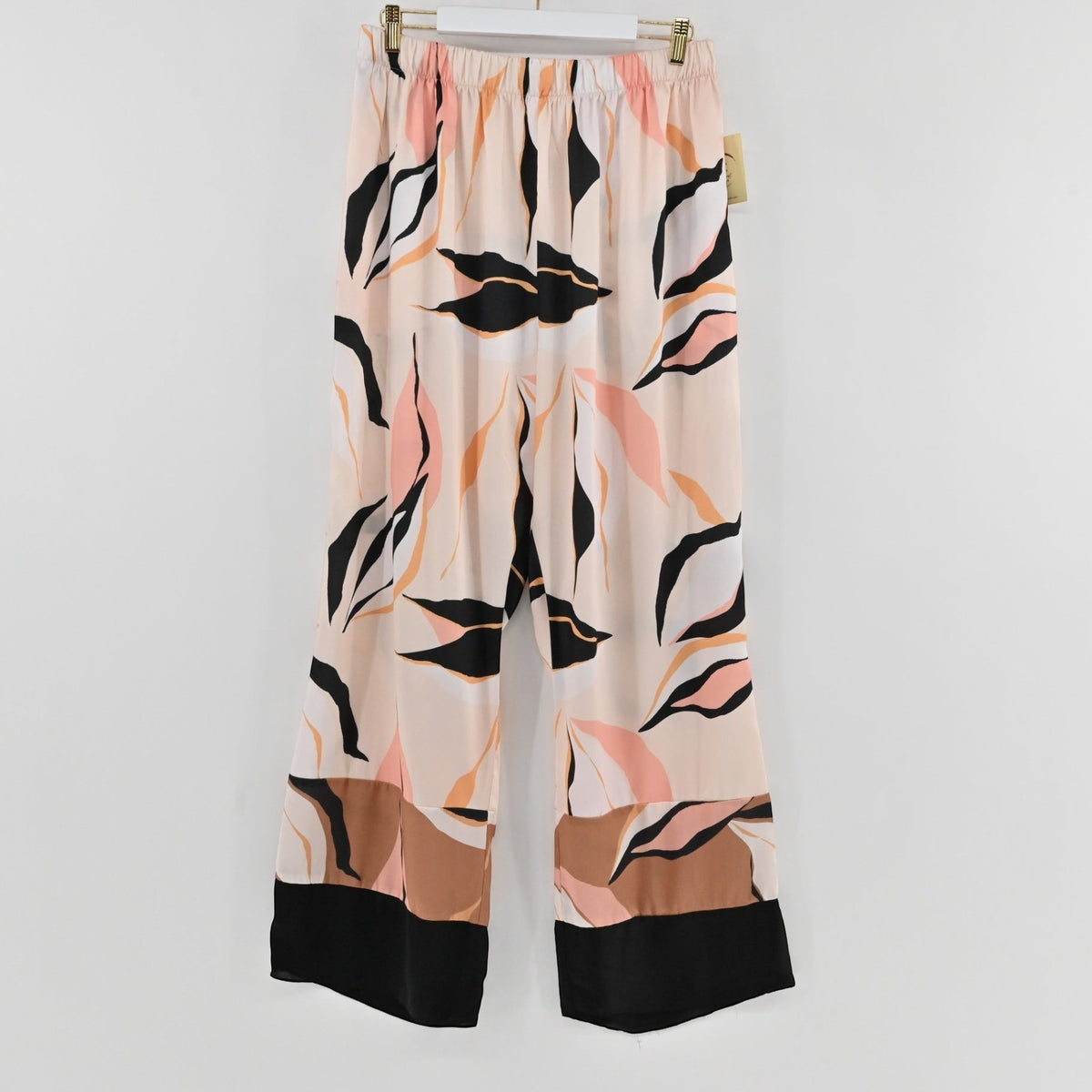Lynn's Closet Boutique satin wide-leg pants with abstract leaf print in blush, tan, and black with a color-blocked hem.