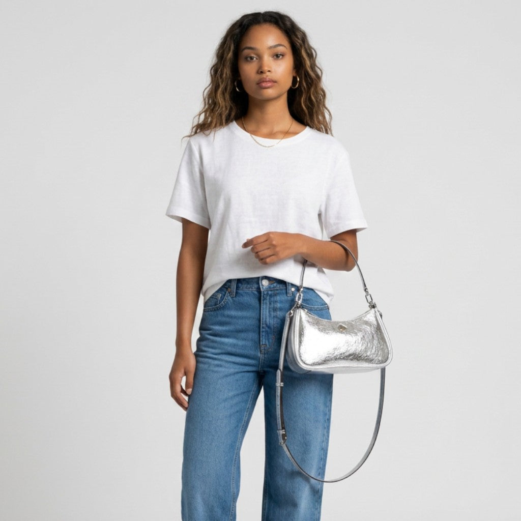 Lynn's Closet Boutique model wearing a white t-shirt and jeans holding a silver crinkle metallic Kate Spade bag