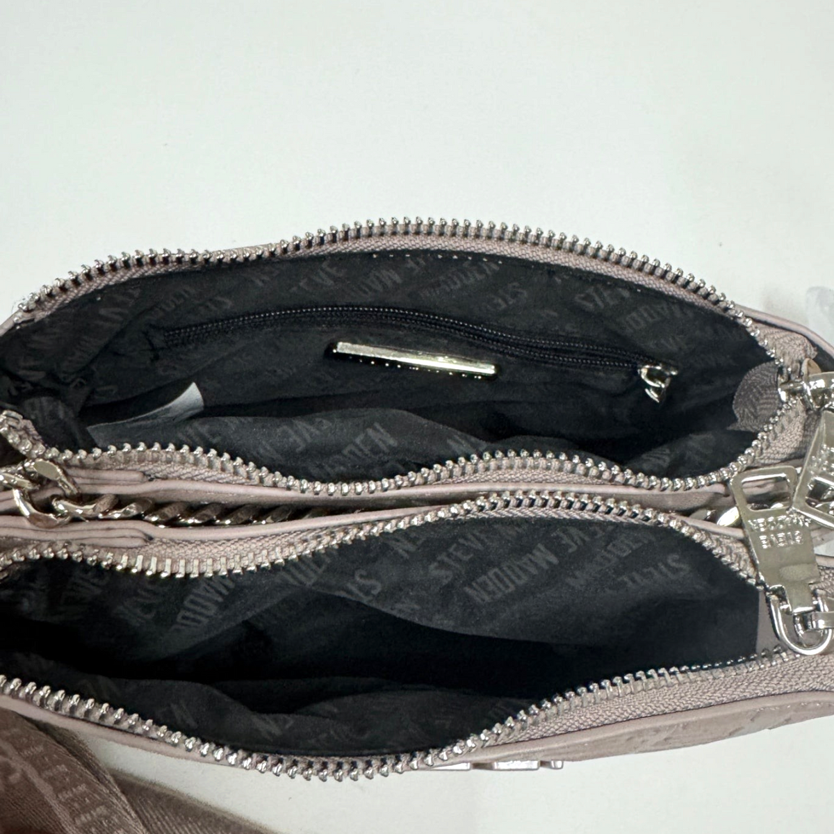 Lynn's Closet Boutique Steve Madden taupe crossbody bag interior showing black logo lining and zippered pockets