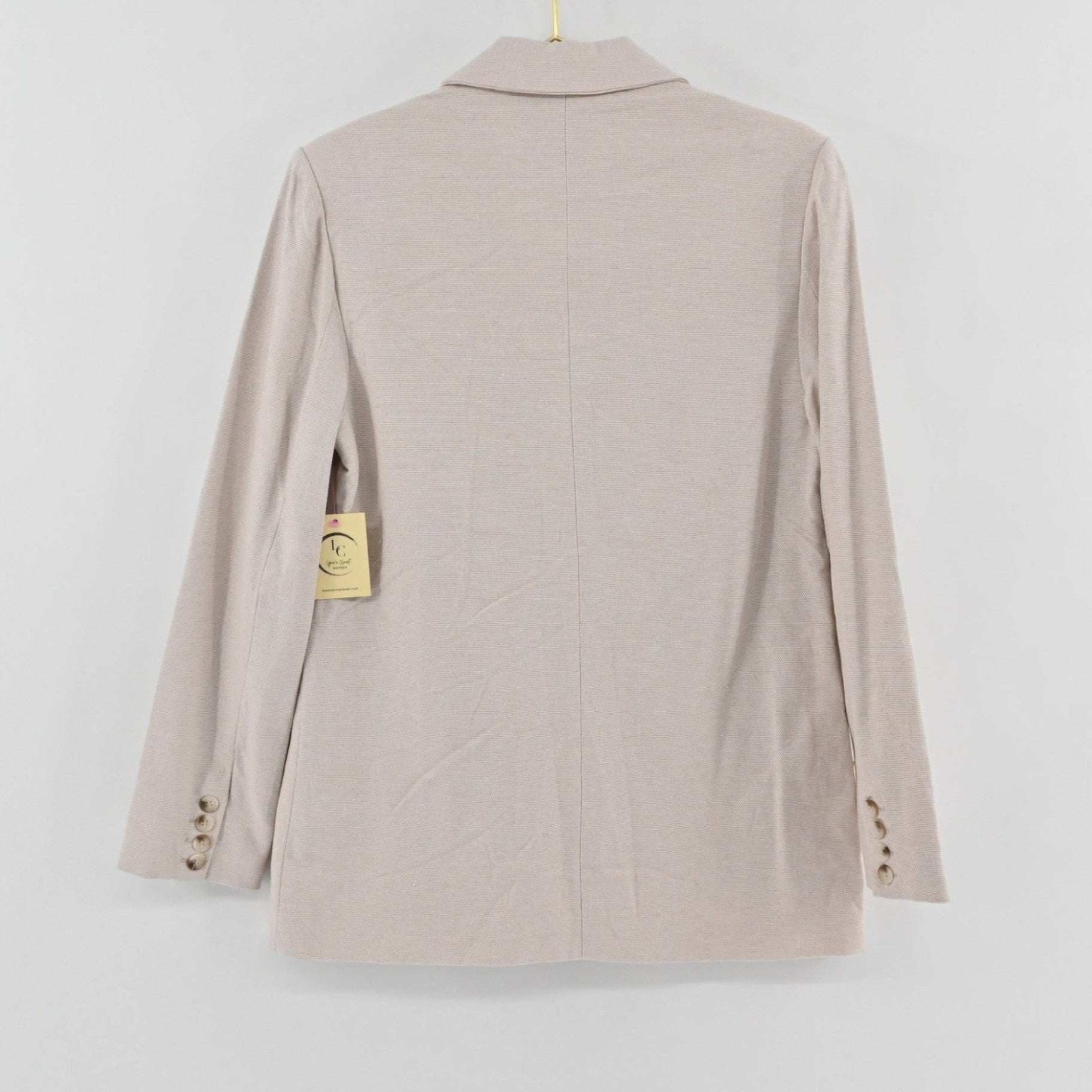 Back view of a tan tweed blazer from Lynn's Closet Boutique featuring long sleeves with button cuffs.